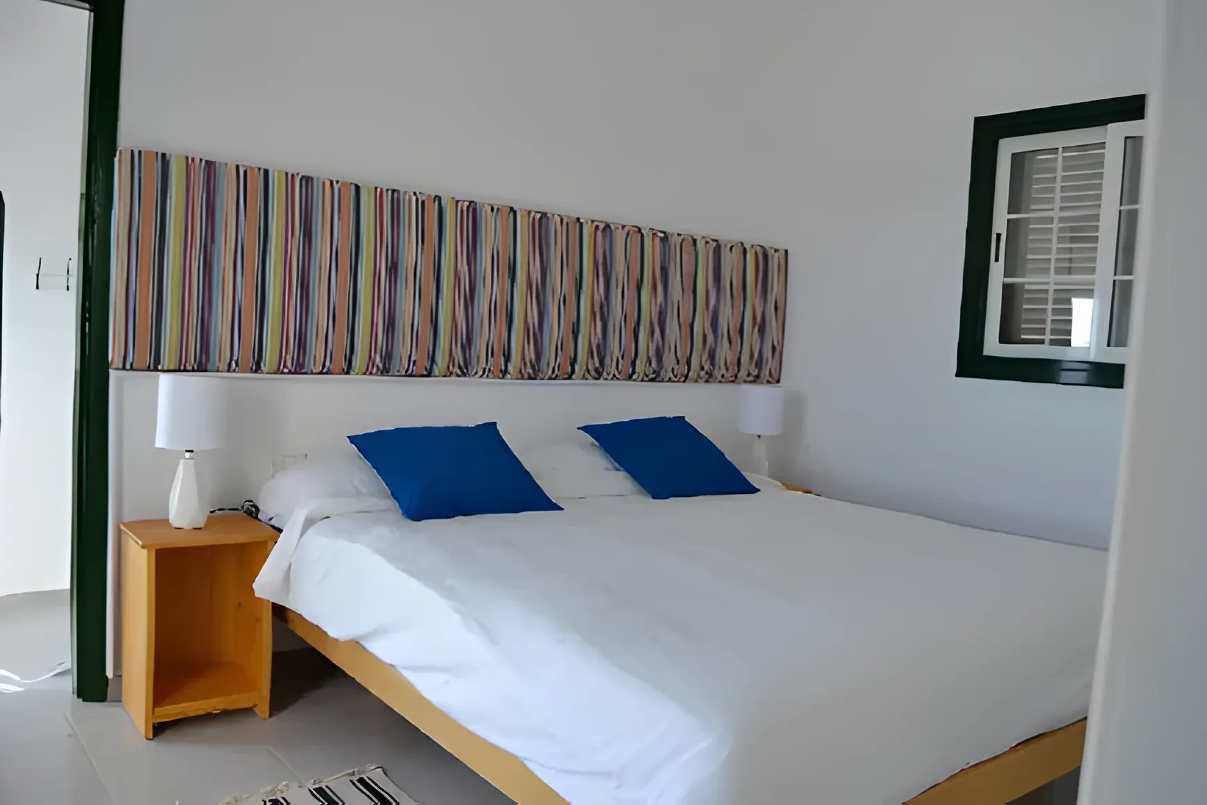 Dormitorio principal con cama doble y cabecero de rayas