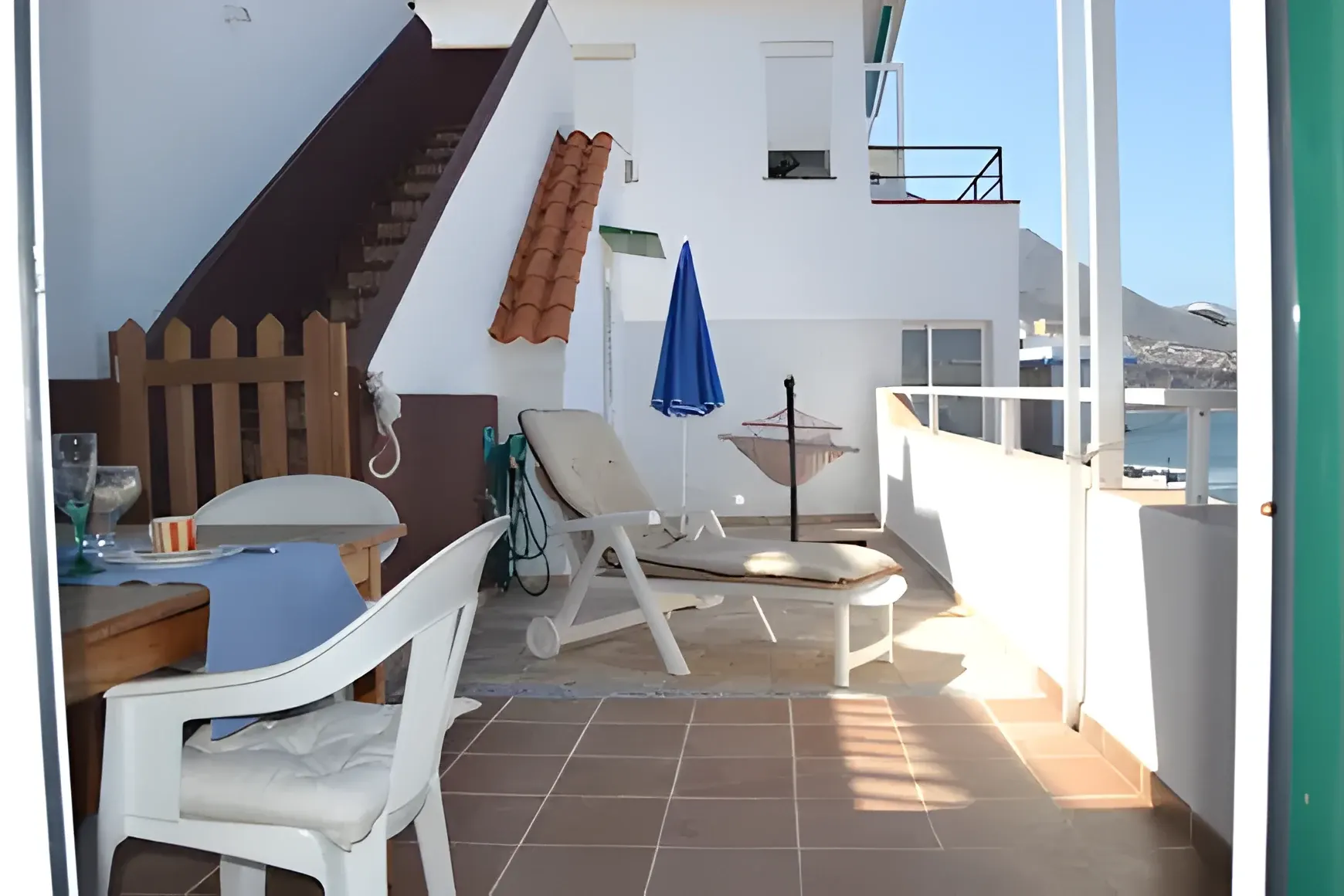 Terraza con sombrilla y zona de descanso al aire libre