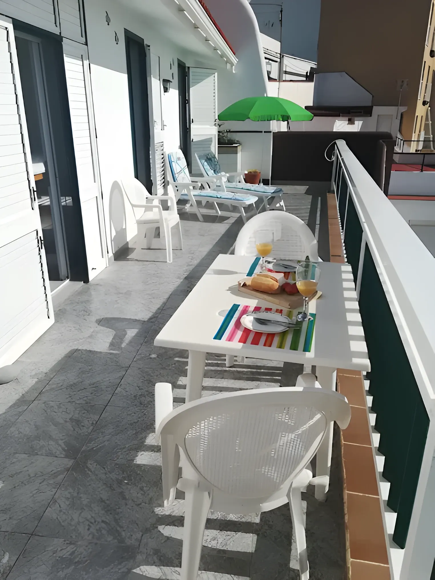 Terraza exterior con mesa y sillas junto a la barandilla